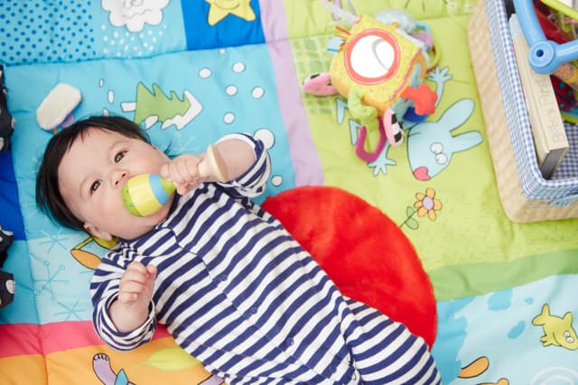 Baby lying on play mat